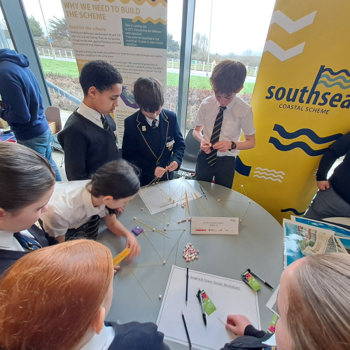 Children at the STEM fair undertaking an activity where they are building structures out of spaghetti and marshmallows.