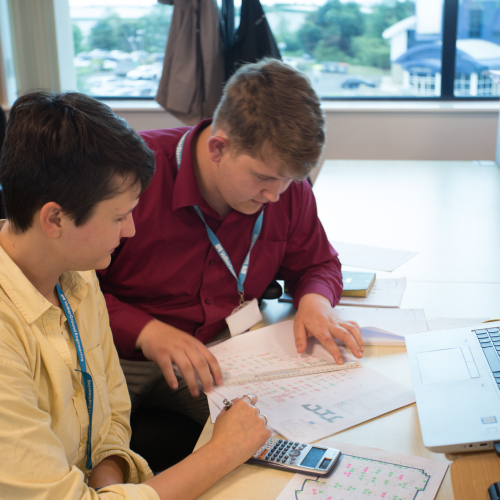 Two people sat at a desk doing work