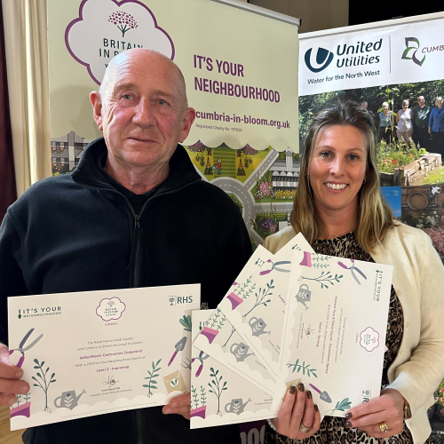 Man and women stood together holding certificates