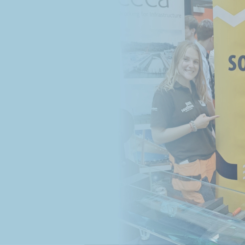 Two women stood alongside a large free standing banner with yellow and blue 