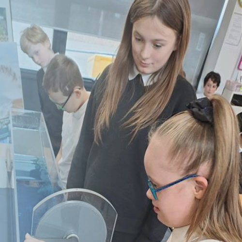 Children stood up doing a demonstration with a water tank