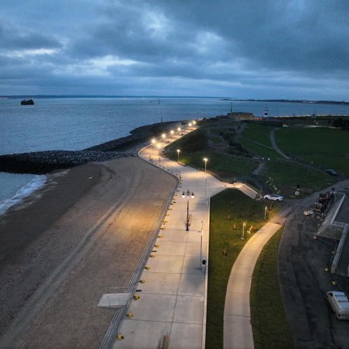 Promenade by the seafront with lights down the side.