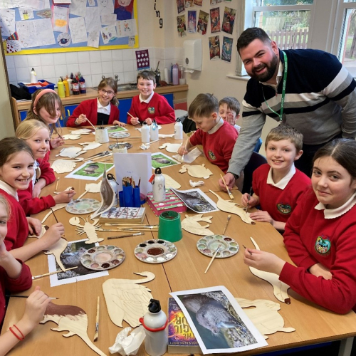 Primary school children sat around a table painting