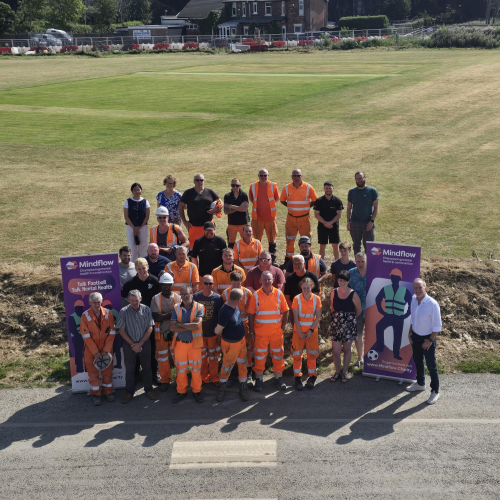 People stood outside next to a banner for a mental health event.