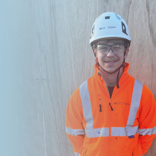 Picture of boy in high-vis smiling at the camera.