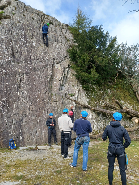 Group of people ready to climb a rock.