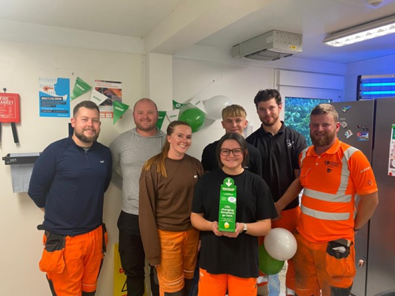 Group photo of men and women in orange hi vis workwear