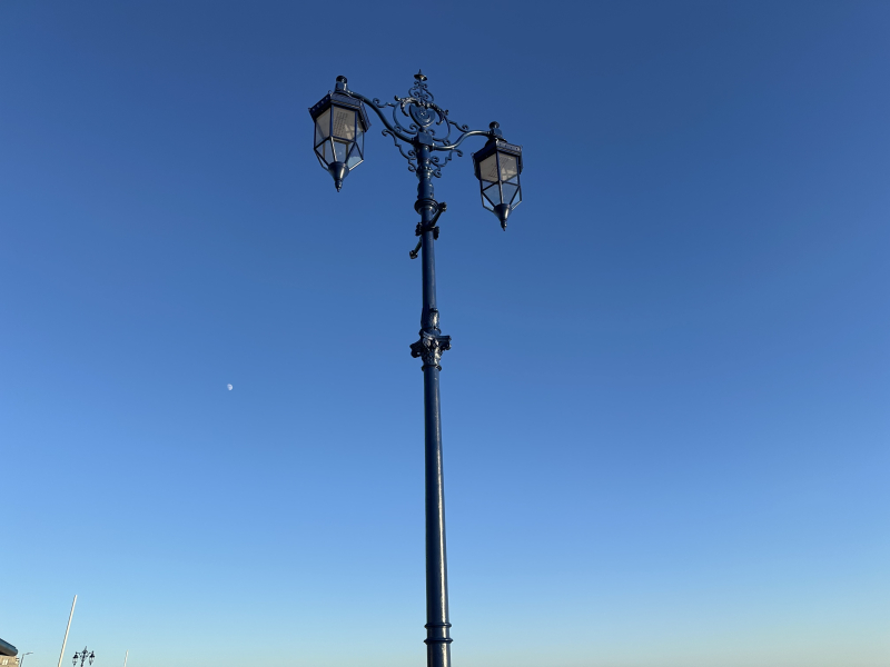 Restored old Victorian lamppost in black with two lamps either side