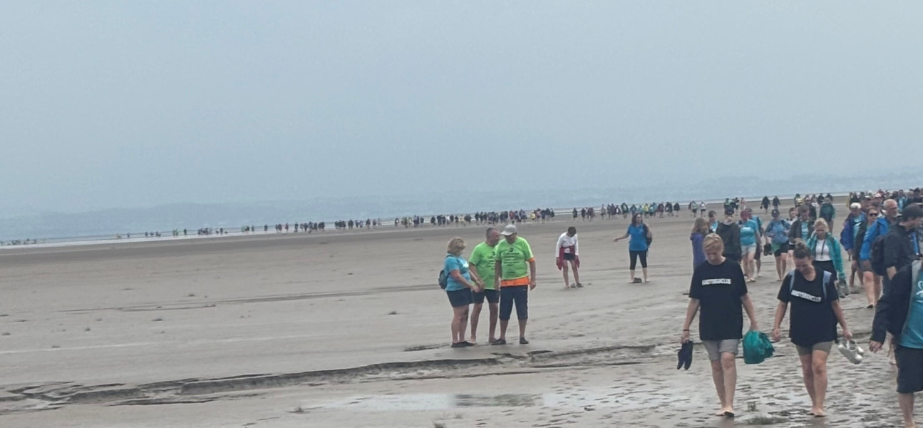 group of people walking across a beach