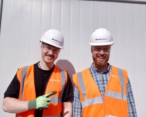 Two people smiling in orange highvis.