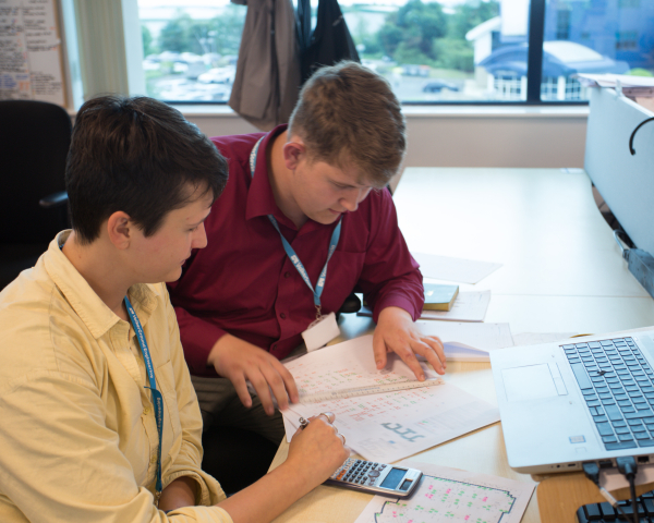 Two people sat at a desk doing work