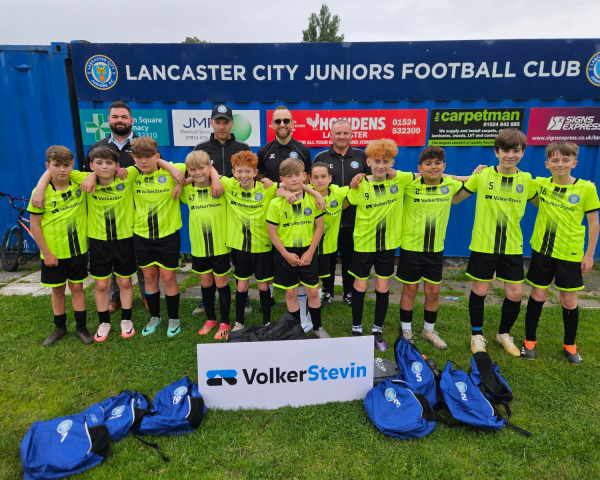 Football team with yellow kits stood outside.