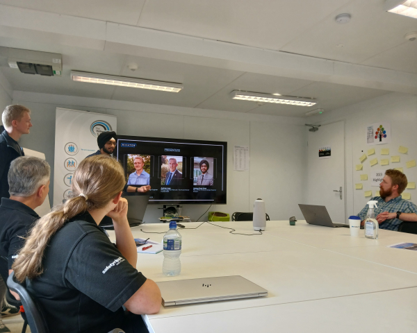 People sat in a room listening to someone talk.