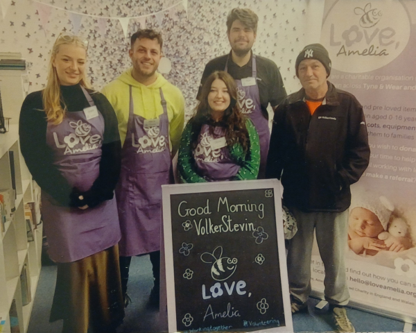 Five people stood in a baby bank charity.