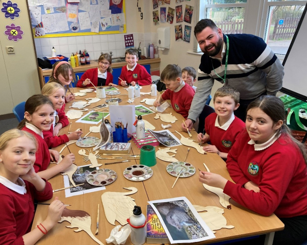Primary school children sat around a table painting