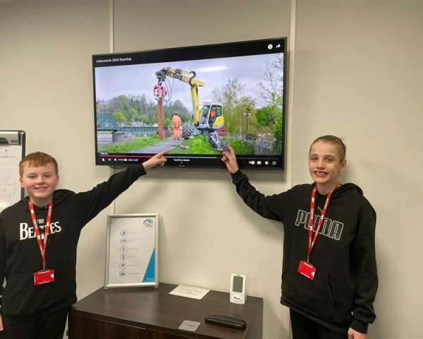 Two young boys pointing at a screen