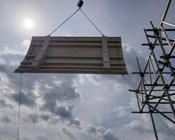 Flood gate being suspended in the air close to scaffolding