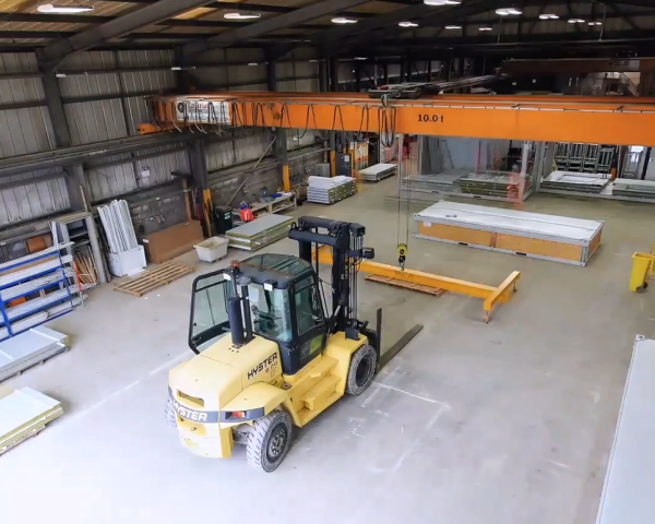 Picture of a forklift placing sit cabins in a wharehouse.