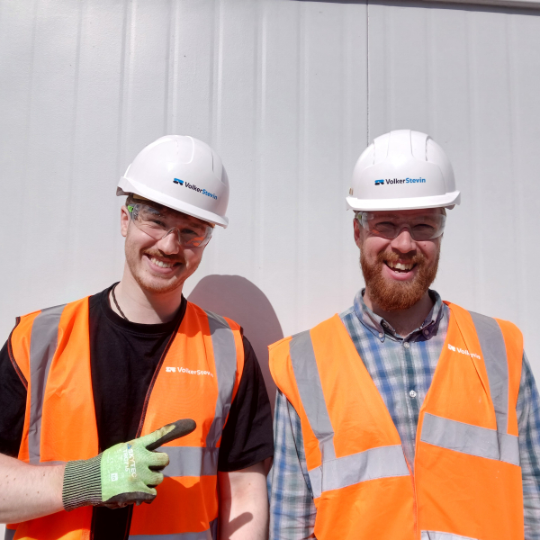 Two people smiling in orange highvis.