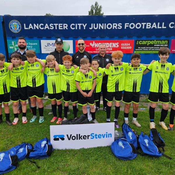 Football team with yellow kits stood outside.