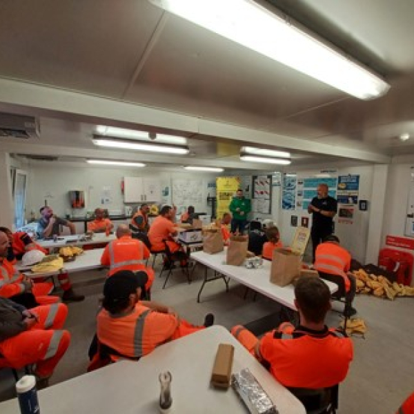 People sat in a room listening to someone talk.