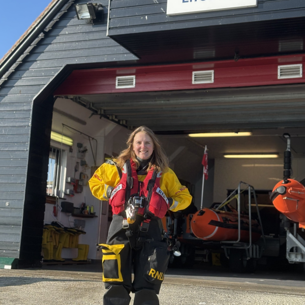 Girl in an RNLI kit outside a boat centre.