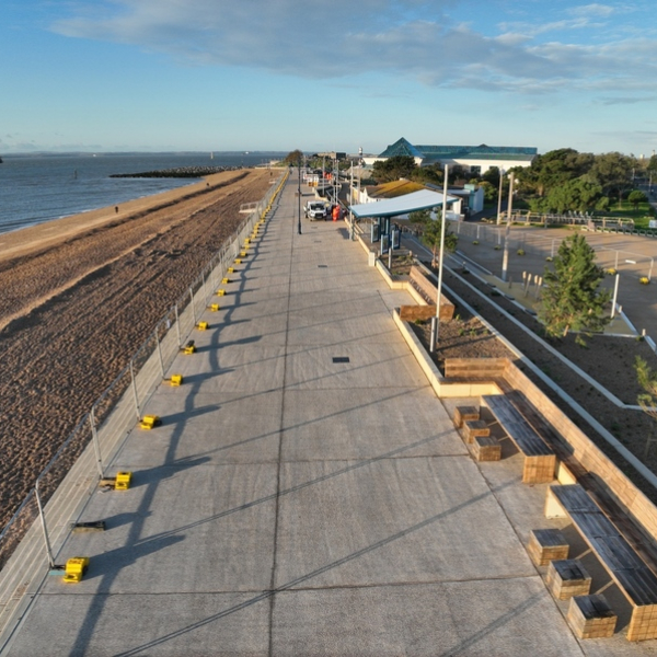 Promenade with beach and see to the leaf of the photo, blue sky