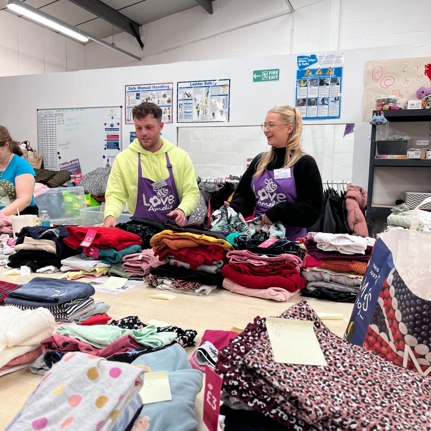 Two people sorting through clothes at a baby bank.