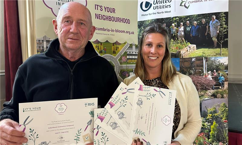 Man and women stood together holding certificates